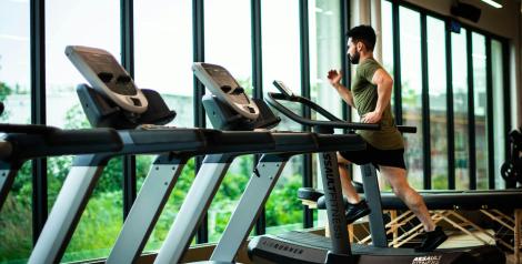 Man in green shirt running on treadmill