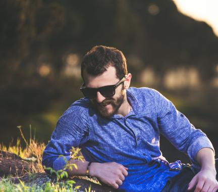 man laying in a field with sunglasses on