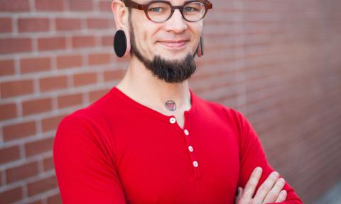 Man with red shirt and gauges in his ears