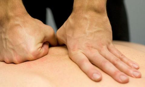 Fist and open hand laid on a person's back for a massage