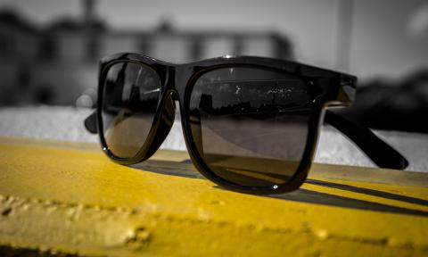 Black sunglasses sitting on a yellow line