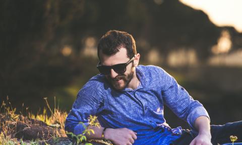 man laying in a field with sunglasses on