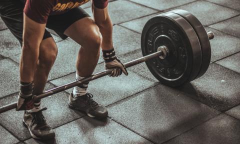 Man getting ready to pick up a barbell with heavy weights