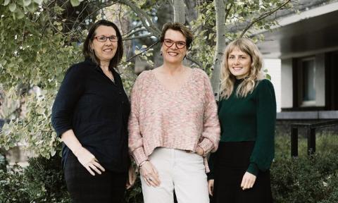 3 women standing in front of a tree