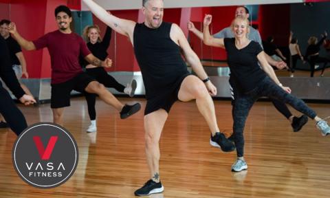 group fitness class with enthusiastic male instructor with Vasa fitness logo on bottom left corner