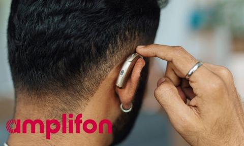 back of man's head with hearing aid and red amplifon logo in bottom left corner