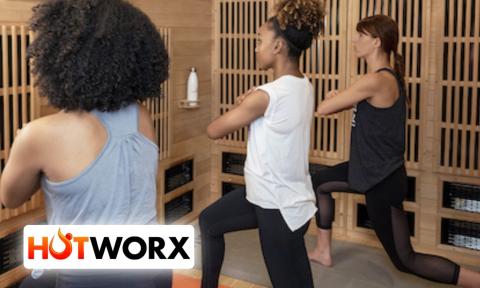 Three women stretching watching a virtual workout, Hotworx logo in bottom left corner