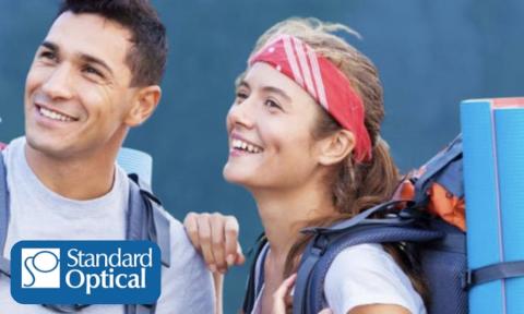 Man and woman with backpacking gear looking into the distance with Standard Optical logo in bottom left corner