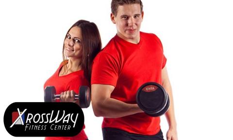 woman and man standing back to back with red shirts, black bottoms and holding a free weight with xrossway fitness logo on bottom left corner