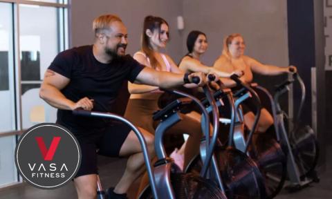 4 people on stationary bikes with Vasa fitness logo on bottom left corner
