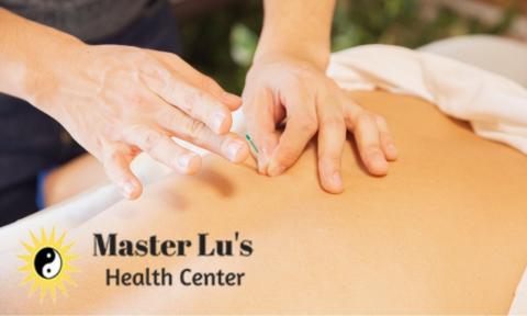 Hands placing acupuncture needle on a back with Master Lu's Health Center logo on bottom left