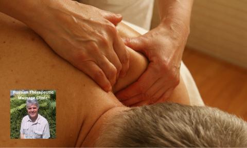 Man laying on front getting shoulders massaged, photo of Sergei Vos, massage therapist in bottom left corner