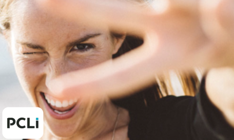 woman giving a peace sign near her eye with PCLi logo on bottom left corner