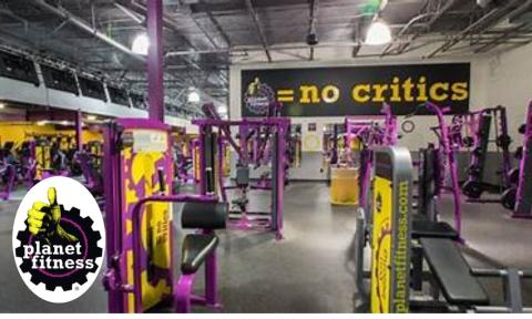 Purple, yellow, and black gym with machines and weights, Planet Fitness logo in bottom left corner