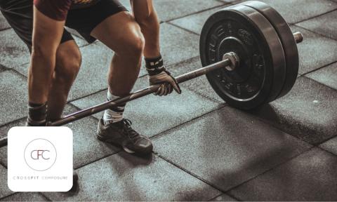 man in black shorts lifting heavy dumbbell, Crossfit Composure logo in bottom left corner