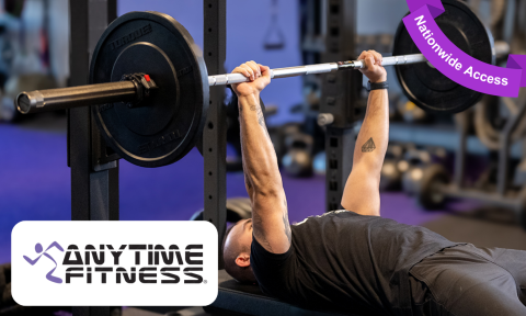 man bench pressing weights with anytime fitness logo in bottom left corner, purple banner reading nationwide access in top right corner