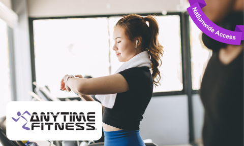 woman with black shirt and blue pants, checking her watch on the treadmill, anytime fitness logo on bottom left corner, purple banner reading nationwide access in top right corner
