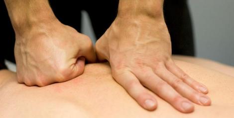 Fist and open hand laid on a person's back for a massage