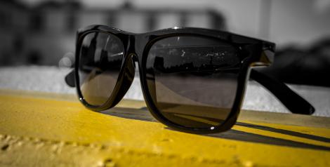 Black sunglasses sitting on a yellow line