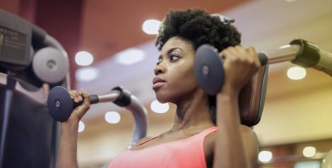 woman with short hair on a weight machine looking focused