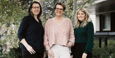 3 women standing in front of a tree