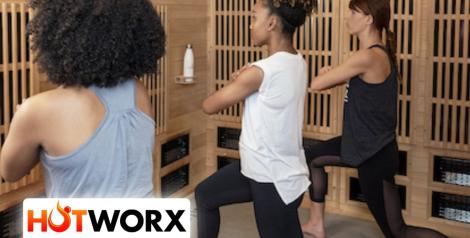 Three women stretching watching a virtual workout, Hotworx logo in bottom left corner