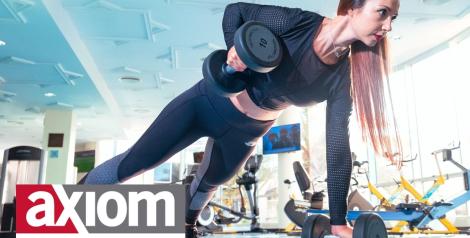 Woman in a plank lifting weights with axiom fitness logo in bottom left corner