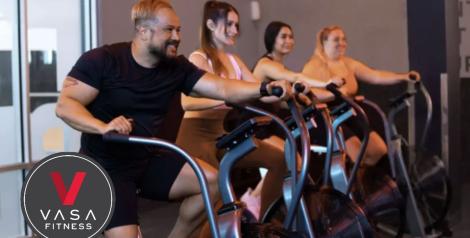 4 people on stationary bikes with Vasa fitness logo on bottom left corner