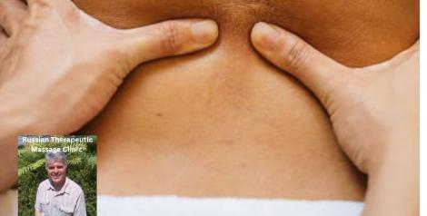 hands massaging a lower back with a white towel on the waist, photo of Sergio Vio massage therapist in bottom left corner