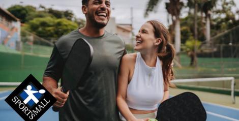 man and woman on pickleball courts laughing together with Sports Mall logo in bottom left corner