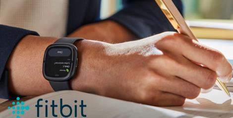 A mans hand with a smartwatch on, fitbit logo in bottom left corner