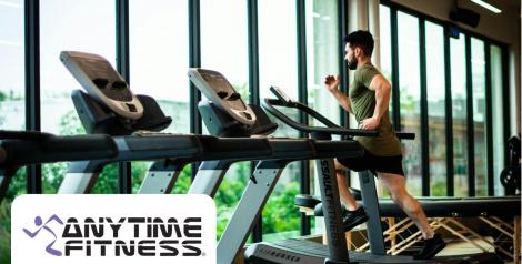 Man in green shirt running on treadmill, anytime fitness logo in bottom left corner