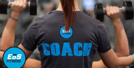 The back of a woman spotting someone with weights, EOS fitness logo in bottom left corner