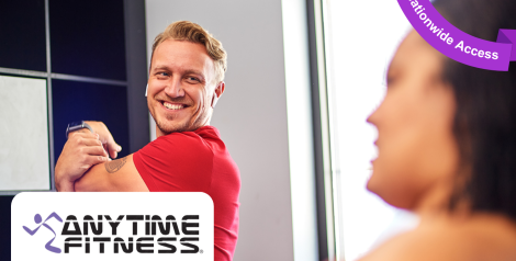 man with a red shirt and blonde hair stretching his arm and smiling, anytime fitness logo in bottom left corner, purple banner reading nationwide access in top right corner