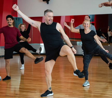 group fitness class with enthusiastic male instructor